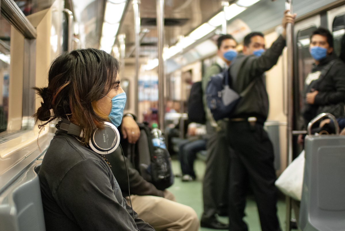 A young woman wearing a protective mask rides the subway in Mexico City, 2009.